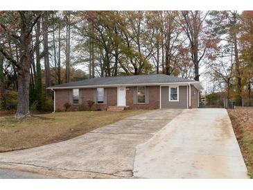 Charming brick home with a well-maintained lawn and long driveway at 679 Winchester Ln, Norcross, GA 30071