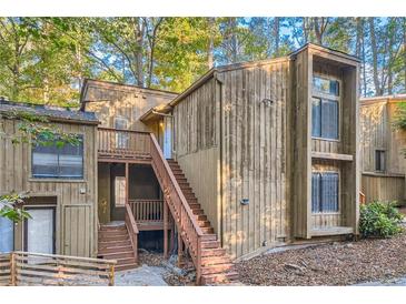 A charming condo featuring a wooden exterior and staircase in a wooded setting at 3111 Fairington Dr, Lithonia, GA 30038