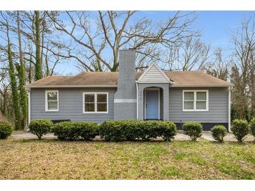 Charming single-story home with gray siding, blue door, brick chimney, and well-maintained landscaping at 360 Peyton Sw Rd, Atlanta, GA 30311