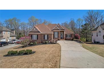 Charming brick home featuring a well-manicured lawn and long driveway at 160 Glenmore Ln, Mcdonough, GA 30253