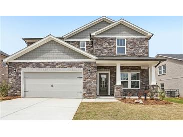 Charming two-story home featuring stone accents, gray siding and a two-car garage at 6910 Winchester Pl, Fairburn, GA 30213