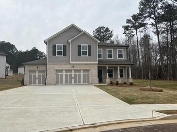 New two-story home featuring a three car garage and neutral exterior paint and landscaping at 2749 Cromwell Ln, Snellville, GA 30039