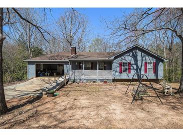 Charming ranch home features an open carport, a front porch and a spacious yard at 180 Sable Cir, Covington, GA 30016