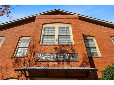Brick building exterior with 'Hapeville Mill' sign, vintage windows and covered entryway creates historic charm at 3371 Dogwood Dr # 220, Hapeville, GA 30354