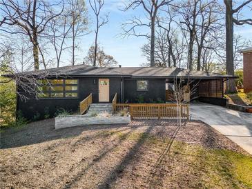 Charming single-story home featuring a black exterior, a wooden porch, and a well-manicured front yard at 2382 Whites Mill Ln, Decatur, GA 30032