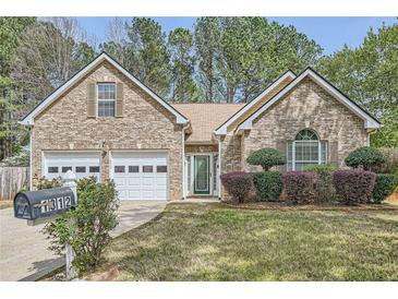 Charming brick home with a well-manicured lawn and a two-car garage at 1312 Birch Ct, Lithonia, GA 30058