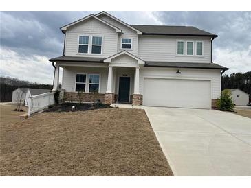 Charming two-story home with a two-car garage, inviting porch, and manicured lawn on an overcast day at 14 Ledgemont Way, Acworth, GA 30101