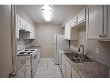 Galley kitchen featuring white cabinets, stone countertops, and matching white appliances at 37 Le Parc Fontaine, Lithonia, GA 30038