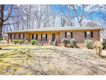 Charming single-story brick home featuring a cozy front porch and well-maintained landscaping at 380 Hidden Valley Sw Dr, Conyers, GA 30094