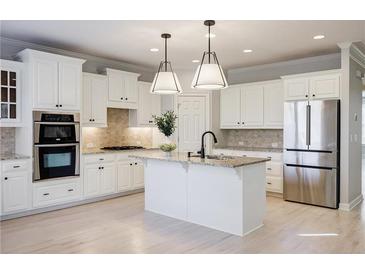 Bright kitchen with white cabinetry, stainless steel appliances, granite countertops and a large island at 5210 Davenport Pl, Roswell, GA 30075