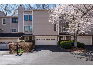 Inviting townhome exterior with attached garage and lovely flowering tree in the front yard at 58 Basswood Cir # 29, Atlanta, GA 30328