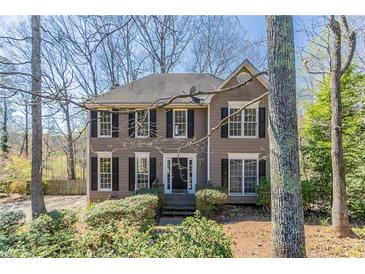 Charming two-story home featuring a symmetrical facade, black shutters, and a well-maintained front yard with mature trees at 2072 Arbor Forest Sw Dr, Marietta, GA 30064