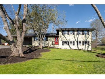 Charming two-story home with landscaped yard and a bright red front door on a sunny day at 399 W Sandtown Sw Rd, Marietta, GA 30064
