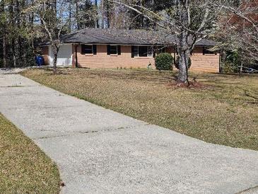 Charming one-story brick home with a well-manicured lawn and long driveway at 3685 Emily Way, Atlanta, GA 30349