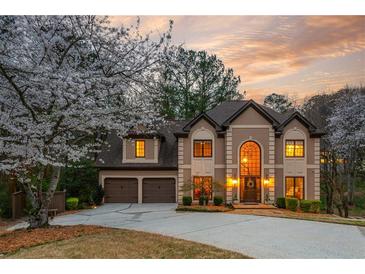 Charming two-story home featuring arched windows, mature trees, two-car garage and beautiful landscaping at 275 Tynebrae Pl, Roswell, GA 30075