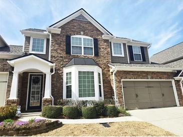 Charming two-story home featuring stone accents, a two-car garage and beautifully manicured landscaping at 2675 Sardis Chase Ct, Buford, GA 30519