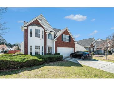 Charming two-story home with a well-maintained lawn and beautiful brick and white siding at 3287 Shady Valley Ln, Loganville, GA 30052