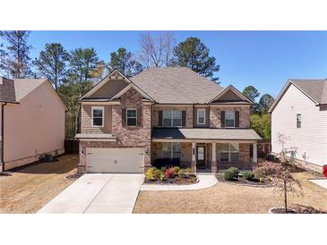 Charming brick-and-siding two-story home with a well-manicured front yard and covered entryway at 3489 Central Park Dr, Loganville, GA 30052