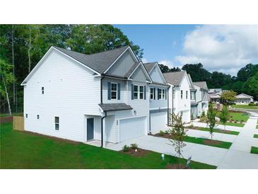 New townhome construction with white siding, gray trim, and manicured lawn and garden at 4276 Notting Hill Dr # 23, Atlanta, GA 30331