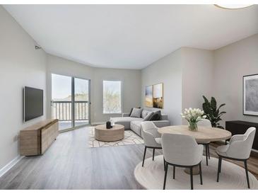Bright living room with modern gray decor, wood floors, and balcony access at 1 Biscayne Nw Dr # 410, Atlanta, GA 30309