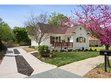 Charming white brick home with a well-manicured lawn and beautiful landscaping, including a mature flowering tree at 102 Rockyford Ne Rd, Atlanta, GA 30317