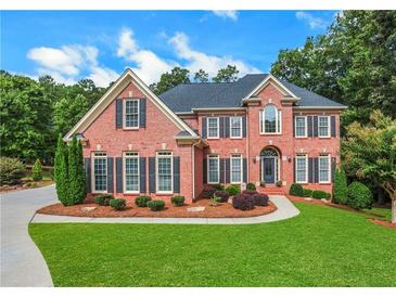 Charming brick home featuring a manicured lawn and lush landscaping, offering great curb appeal at 2930 Monticello Dr, Cumming, GA 30041