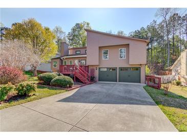 Inviting two-story home with a two-car garage, deck, and well-maintained landscaping at 5494 Princeton Oaks Ln, Sugar Hill, GA 30518