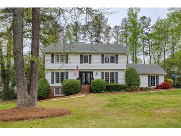 Charming two-story home featuring a manicured front lawn and traditional architectural details at 240 Pinebrook Way, Roswell, GA 30076