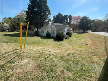 Charming single-story home with a classic design, nestled in a tranquil, tree-filled landscape with a well-maintained lawn at 1520 Bells Ferry Rd, Marietta, GA 30066