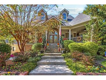 Charming home featuring a stone stairway, manicured landscaping, and covered porch perfect for relaxing at 90 W Peachtree St, Norcross, GA 30071
