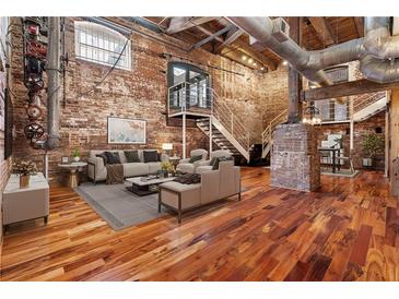 Spacious industrial-style living room with exposed brick, ductwork, and an open floor plan at 490 Marietta Nw St # 105, Atlanta, GA 30313