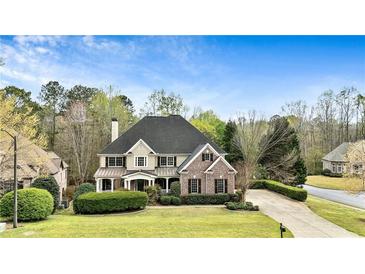 Charming brick and siding home with manicured lawn and mature trees, perfect for suburban living at 500 Poplar Creek Xing, Canton, GA 30114
