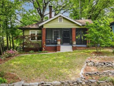 Charming bungalow with a well-manicured lawn, stone wall and inviting greenery at 646 Catherine Sw St, Atlanta, GA 30310