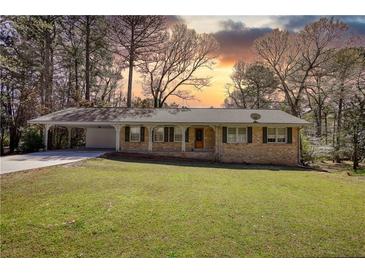 Charming brick ranch-style home with a well-manicured front yard and covered carport at 1295 Maple St Se, Conyers, GA 30013