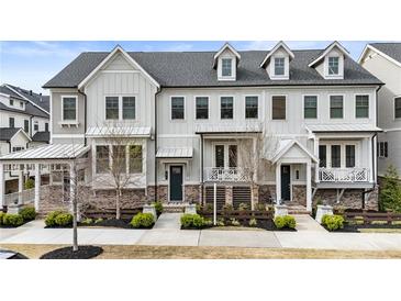 Charming townhome exterior with dormer windows, a porch, and manicured landscaping at 884 Mayfield Rd, Milton, GA 30009