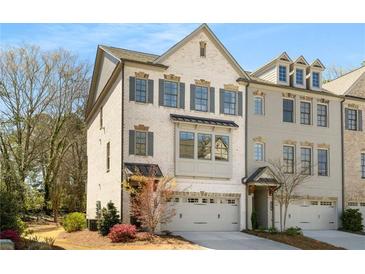 Charming two-story townhome with brick facade, gray shutters, and attached two-car garage at 2468 Skyland Ne Dr # 32, Atlanta, GA 30319
