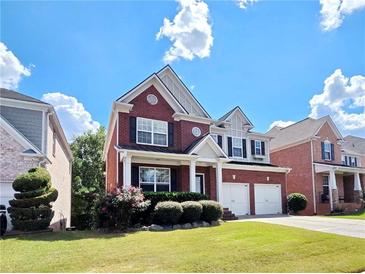 Charming two-story red brick home with a well-manicured lawn and a two-car garage at 2921 Royston Dr, Duluth, GA 30097