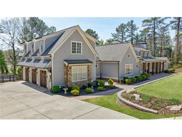 Beautiful two-story home with a three car garage, stone accents, and well manicured landscaping at 3680 Sewell Mill Rd, Marietta, GA 30062