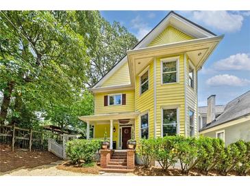 Charming yellow two-story home with a welcoming front porch and beautifully landscaped front yard at 518 Hill St Se, Atlanta, GA 30312