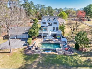 Expansive backyard featuring a large swimming pool and an outdoor lounge area, perfect for relaxation and entertainment at 1768 Hood Rd, Dacula, GA 30019