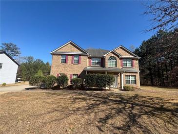 Traditional two-story brick home with well-manicured front yard and red shutters at 5761 Harrier Ln, Atlanta, GA 30349