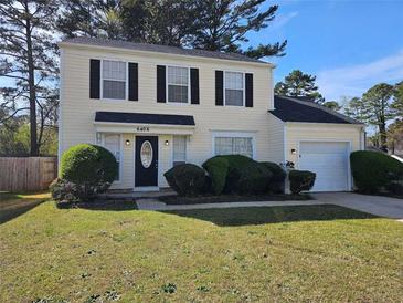 Inviting two-story home features a well-manicured front yard and a classic design with black shutters at 6406 Laurel Post Dr, Lithonia, GA 30058