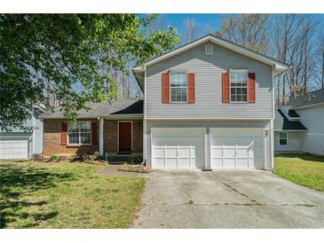 Charming two-story home with brick and siding exterior and a two-car garage at 7324 Drake Ave, Lithonia, GA 30058