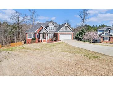 Charming two-story home with brick accents, gray siding and a well-manicured lawn on a sunny day at 1092 Shumard Ln, Mcdonough, GA 30252