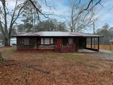 Cozy single-story home featuring a covered carport and a quaint front porch at 3844 Oglesby Rd, Powder Springs, GA 30127