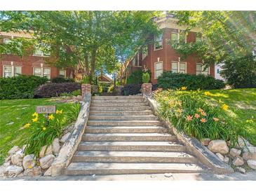 Charming brick building showcasing a long stairwell entrance surrounded by vibrant flowers and lush greenery at 1015 Piedmont Ne Ave # A2, Atlanta, GA 30309