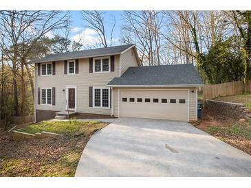 Charming two-story home with tan siding, dark shutters, and an attached two-car garage at 3569 Vinyard Way, Lawrenceville, GA 30044