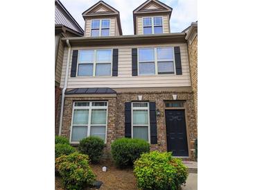 Two story townhome with brick and siding, black shutters, and a well-maintained front yard at 540 Ridge View Xing, Woodstock, GA 30188