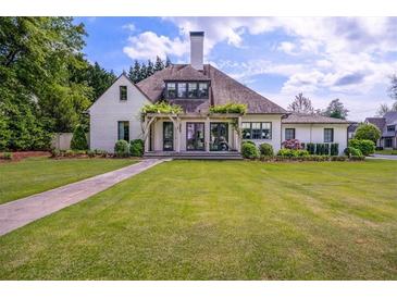 Charming home with lush landscaping, a stone walkway, and an inviting covered porch with pergola at 406 Whitmore Nw Dr, Atlanta, GA 30305