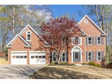 Charming brick home with a well-manicured lawn and attached two-car garage, and mature landscaping at 4955 Day Lily Nw Way, Acworth, GA 30102